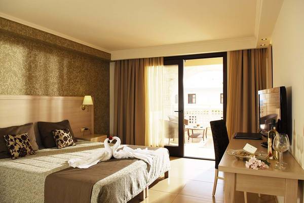 Hotelzimmer im Cactus Royal mit Bett, zwei Schwänen, Fernseher und Balkon.