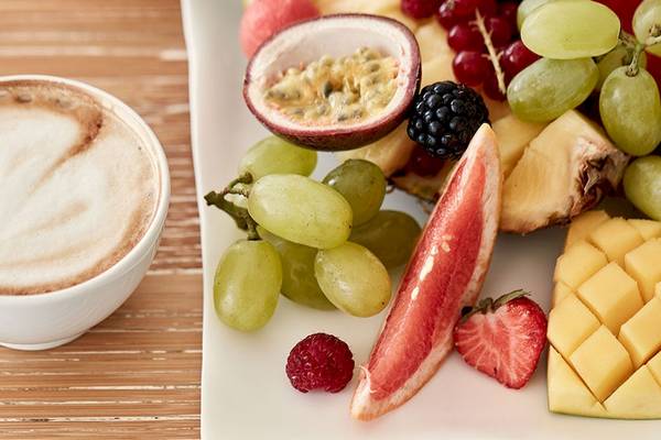 Früchte und Kaffee auf einem Holztisch, Myconian Utopia Resort
