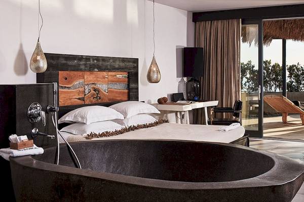 Luxuriöses Schlafzimmer mit freistehender Badewanne im Myconian Utopia Resort.