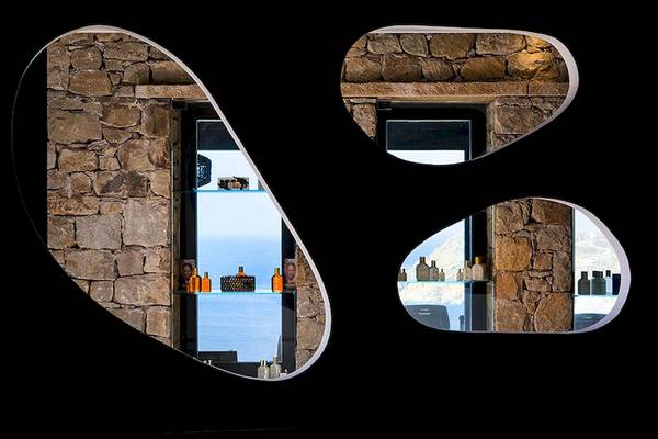 Steinwand mit Spiegeln im Myconian Utopia Resort, Blick auf das Meer.
