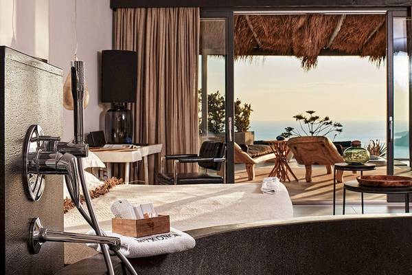 Hotelzimmer im Myconian Utopia Resort mit Aussicht auf den Ozean und einem großen Bett.