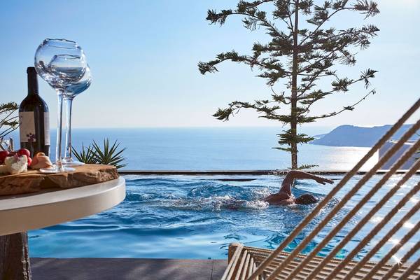 Schwimmer im Pool des Myconian Utopia Resorts mit Blick auf den Ozean