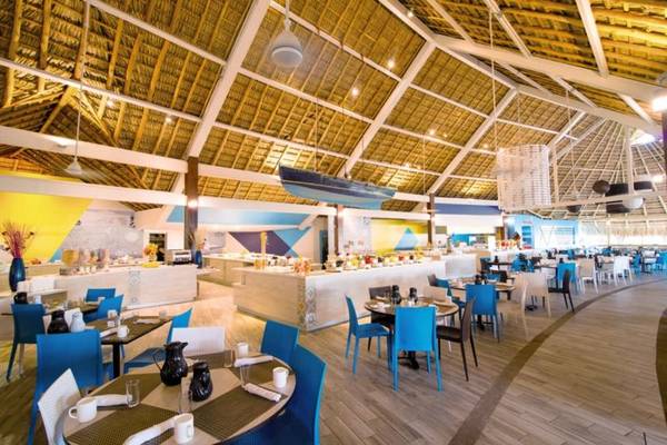 Innenansicht des Restaurants im Fiesta Resort All Inclusive mit blauen Stühlen und Tischen.