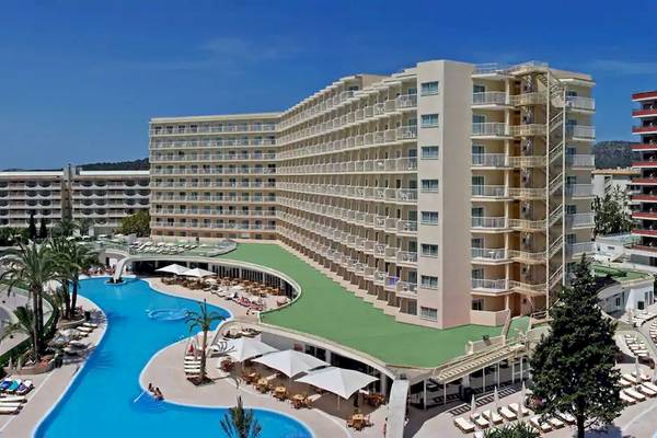 Außenansicht des Sol Guadalupe Hotels mit Swimmingpool und Sonnenliegen.