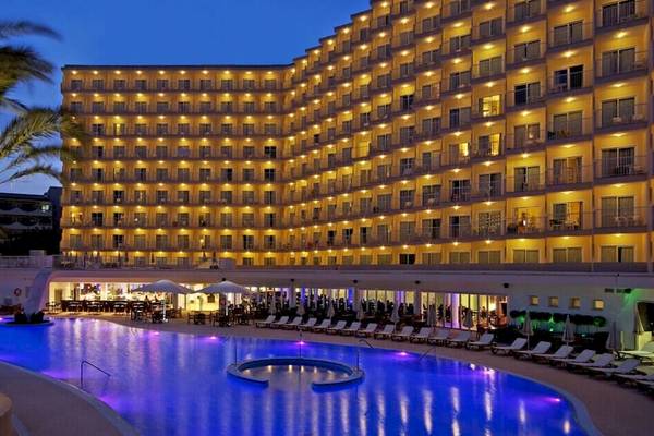Das Sol Guadalupe Hotel bei Nacht mit beleuchteten Fenstern und einem großen Pool.