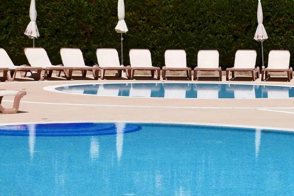 Schwimmbeckenbereich des Sol Guadalupe Hotels mit weißen Liegestühlen und Sonnenschirmen.