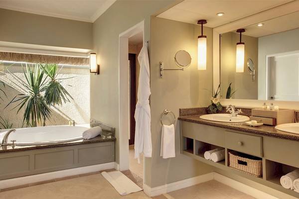 Badezimmer im Outrigger Mauritius Beach Resort mit Badewanne und Waschbecken.