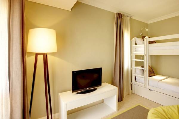 Kinderzimmer im Outrigger Mauritius Beach Resort mit Etagenbett, Fernseher und Lampe.
