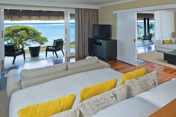 Wohnbereich im Outrigger Mauritius Beach Resort mit Blick auf das Meer und eine Terrasse.