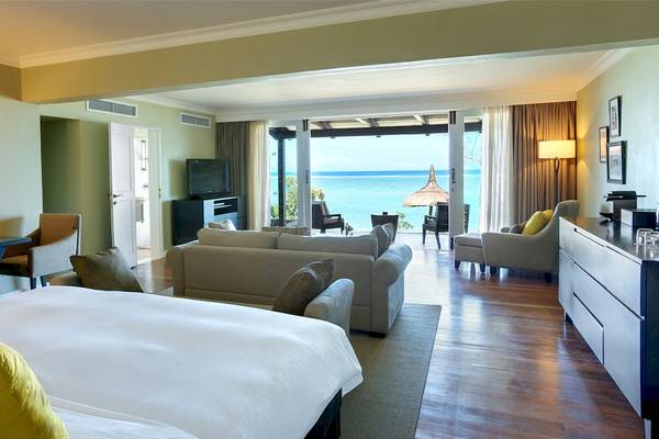 Suite im Outrigger Mauritius Beach Resort mit Blick auf den Ozean und modernen Möbeln.