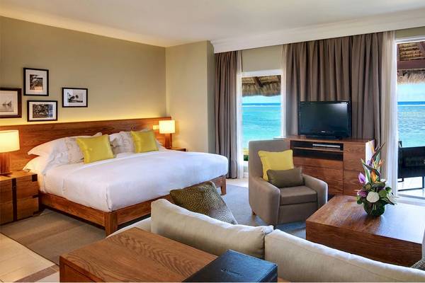 Zimmer im Outrigger Mauritius Beach Resort mit Blick auf das Meer und einen Fernseher.