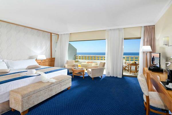 Hotelzimmer des Athena Royal Beach Hotel mit Meerblick, modernen Möbeln und Annehmlichkeiten.