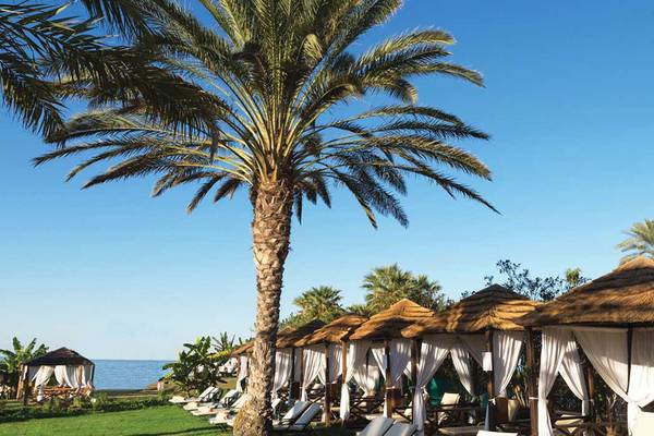 Reihe von Sonnenliegen am Strand des Athena Royal Beach Hotels.