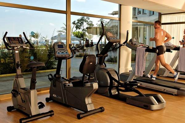 Fitness Center im Athena Royal Beach Hotel mit Laufband und anderen Geräten.