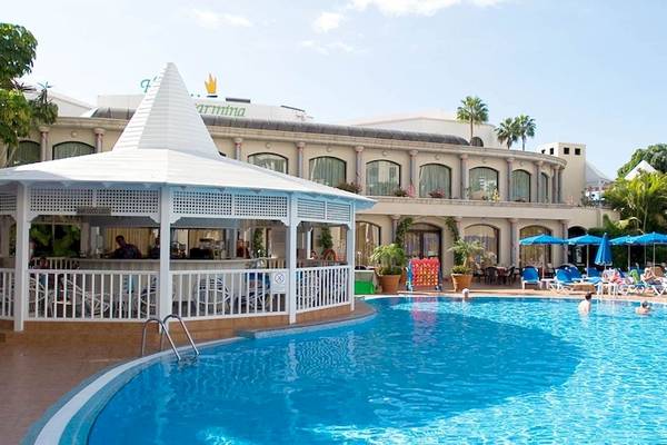 Außenpoolbereich des Princess Inspire Tenerife Hotels mit Sonnenschirmen und Liegestühlen.