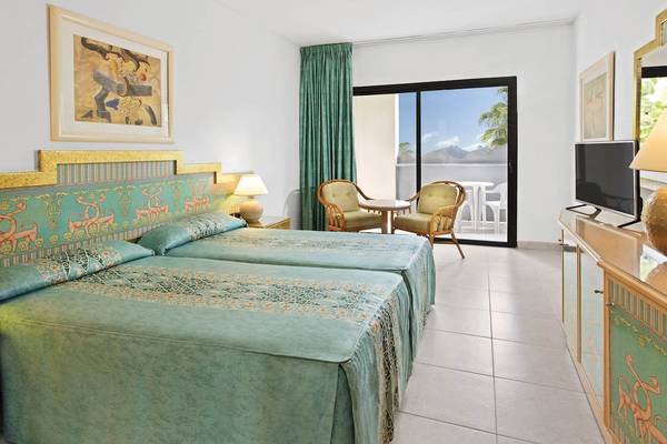 Zimmer mit Doppelbetten und Balkon im Princess Inspire Tenerife Hotel.