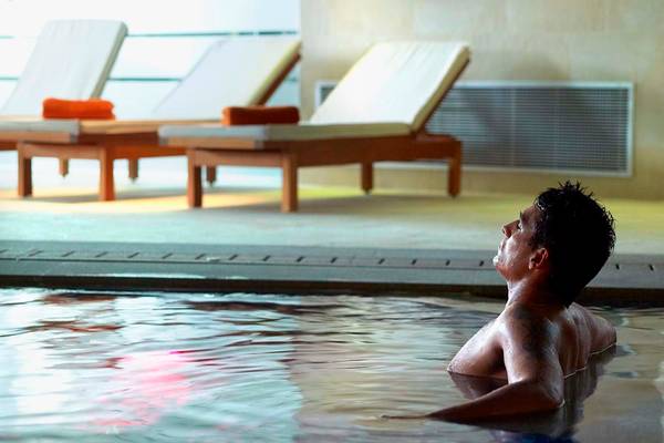 Mann im Schwimmbad des Royal Blue Resorts mit Blick nach oben