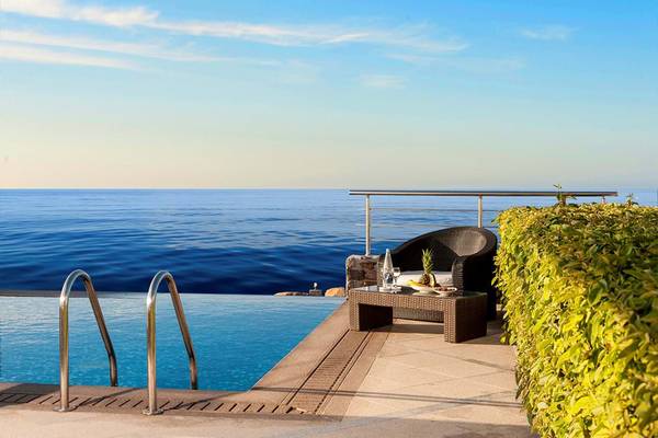 Außenbereich des Royal Blue Resorts mit Blick auf den Ozean, inklusive Swimmingpool und Loungebereich.