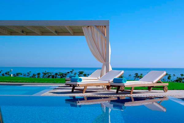 Außenbereich des Royal Blue Resorts mit Pool und Sonnenliegen.