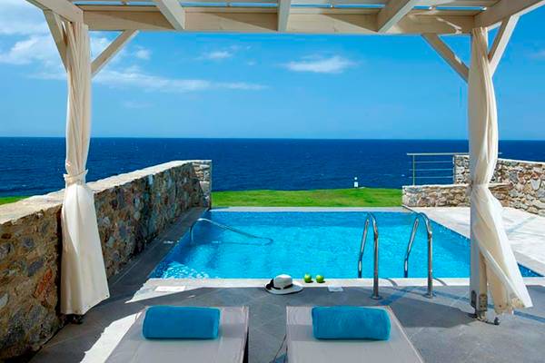 Außenbereich des Royal Blue Resorts mit Swimmingpool und Blick auf das Meer
