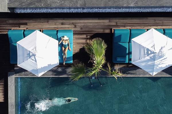 Luftaufnahme des Pools im Mitsis Summer Palace Beach Hotel mit Liegen und Sonnenschirmen.