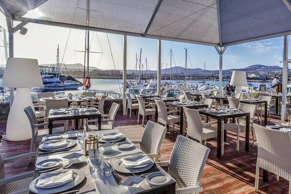 Terrasse des Barcelo Fuerteventura Castillo Hotels mit Blick aufs Meer und Yachten.