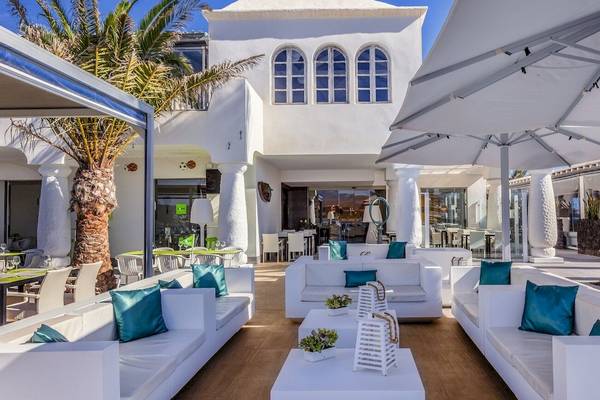 Außenbereich des Barcelo Fuerteventura Castillo Hotels mit weißen Sofas, Tischen und Palmen
