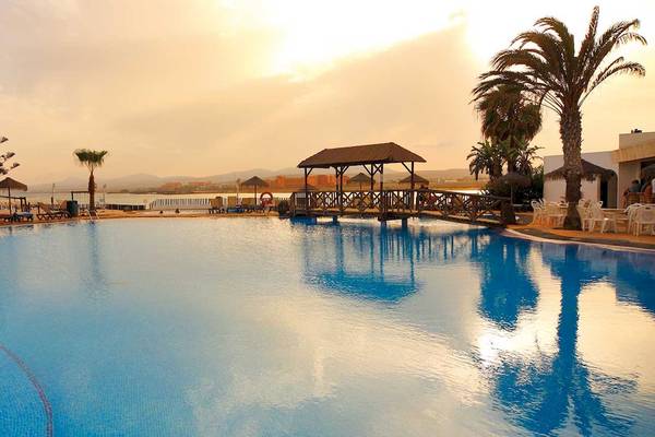 Außenpool des Barcelo Fuerteventura Castillo Hotels mit Brücke und Sonnenliegen.