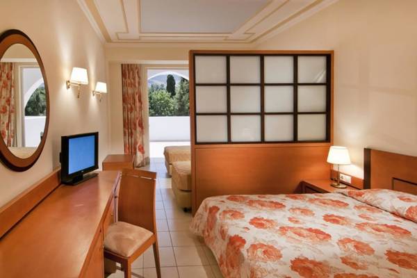 Innenansicht eines Zimmers im Platanista Hotel mit Bett, Schreibtisch und Fernseher