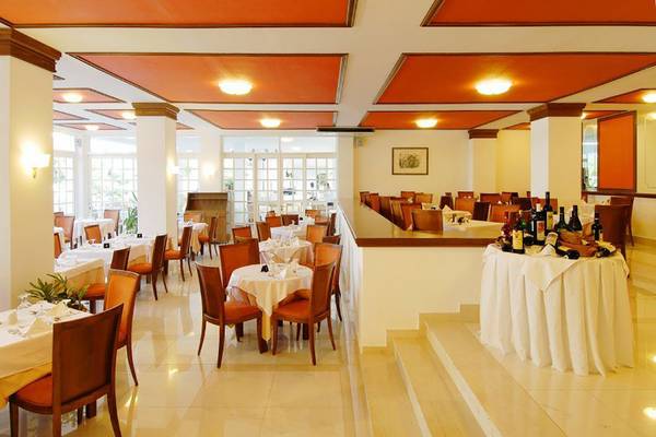 Innenansicht des Platanista Hotel Restaurants mit Tisch und Stühlen, Flaschen und Wein.