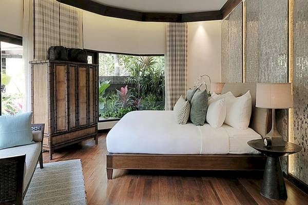 Schlafzimmer im Rayavadee Hotel mit Blick auf den Garten durch große Fenster.