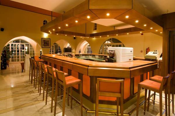 Rezeption des Platanista Hotels mit Bar und orangefarbenen Stühlen.