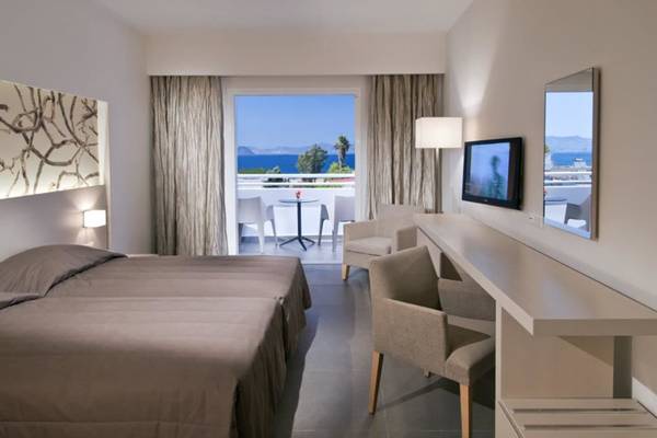 Doppelzimmer im Platanista Hotel mit Blick auf das Meer und Möbeln auf dem Balkon.