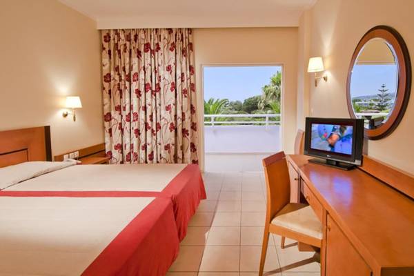 Doppelbettzimmer im Platanista Hotel mit Balkon und Fernseher.