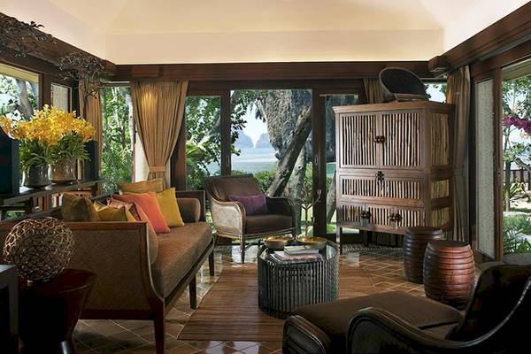 Wohnzimmer im Rayavadee Hotel mit Blick auf das Meer und Bäume.