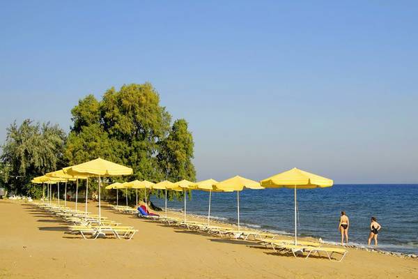 Strand am Platanista Hotel mit gelben Sonnenschirmen und Sonnenliegen