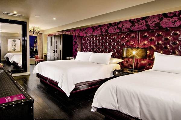 Doppelbettzimmer im The Cromwell Las Vegas Hotel & Casino mit roten Kopfteilen und weißen Laken.