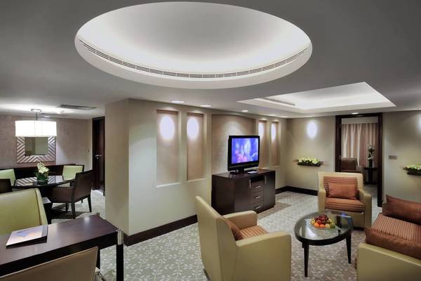 Ein geräumiges Hotelzimmer mit Fernseher, Esstisch, Sofas und Dekoration im Intercontinental Abu Dhabi.