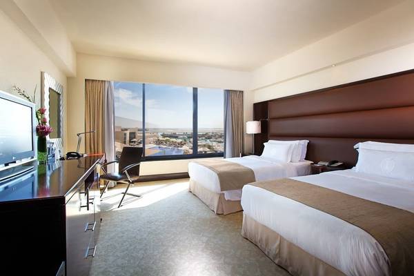 Zimmer im Intercontinental Abu Dhabi mit zwei Betten und Aussicht auf das Meer.