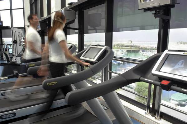 Fitnessstudio im Intercontinental Abu Dhabi mit zwei Personen, die auf Laufbändern laufen.