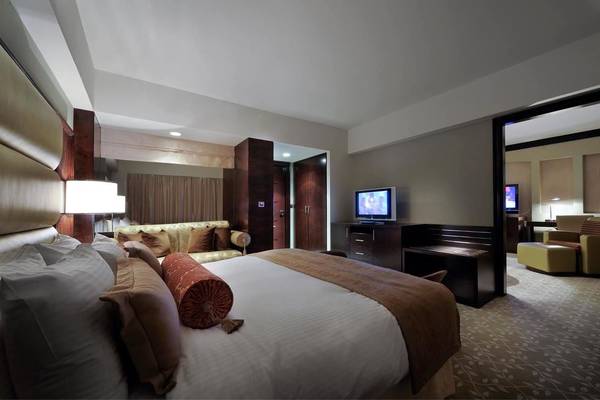 Luxuriöses Zimmer im Intercontinental Hotel Abu Dhabi mit Bett, Sofa, Fernseher und Nachttisch.