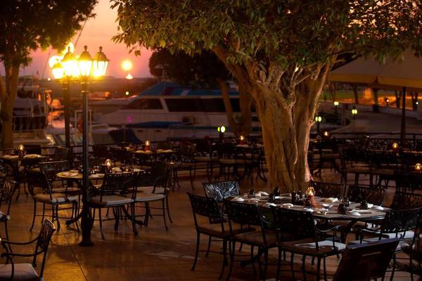 Außenbereich des Restaurants des Intercontinental Abu Dhabi mit stimmungsvollen Lampen und Tischen im Freien