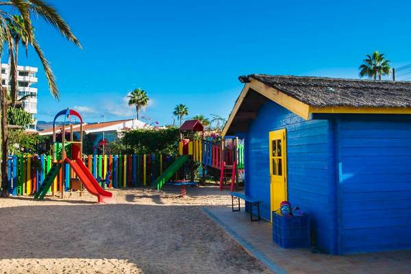 Kinderspielplatz mit bunten Rutschen und Sandkasten im Freien neben HL Miraflor Suites