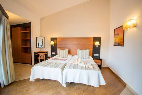 Doppelzimmer im HL Miraflor Suites Hotel mit zwei Betten, Nachttischen und einem Schreibtisch.