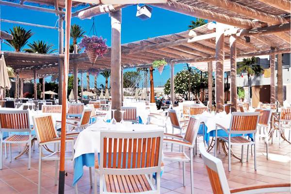 Restaurant Terrasse im Alexandre Hotel Troya mit Tischen und Stühlen unter einem Pergoladach.