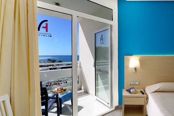 Balkon im Alexandre Hotel Troya mit Blick auf das Meer und blaue Wände.