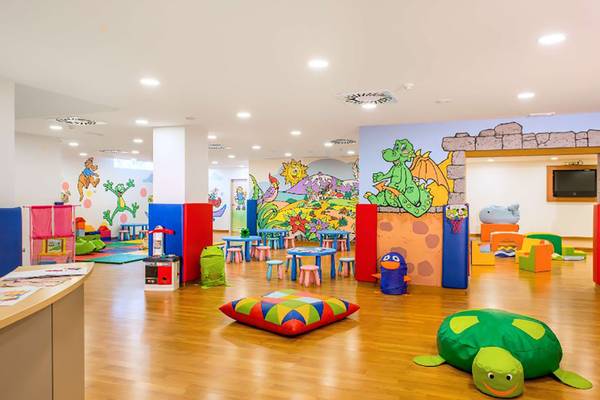 Kinderspielzimmer im Alexandre Hotel Troya mit bunten Möbeln und Wandmalereien.
