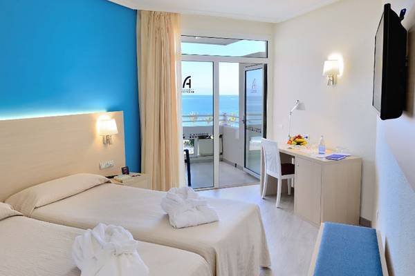 Doppelzimmer im Alexandre Hotel Troya mit Meerblick, zwei Betten, Schreibtisch und Balkon.