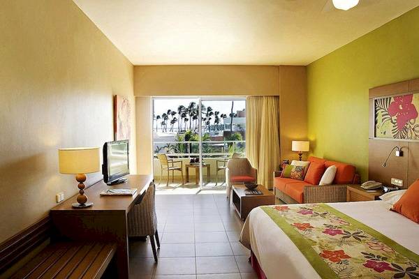 Suite-Zimmer im Secrets Royal Beach Punta Cana mit Blick auf die Terrasse und das Meer.