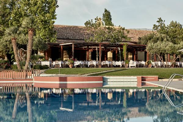 Außenansicht des Candia Park Village Hotels mit Swimmingpool und bewirtetem Restaurant.